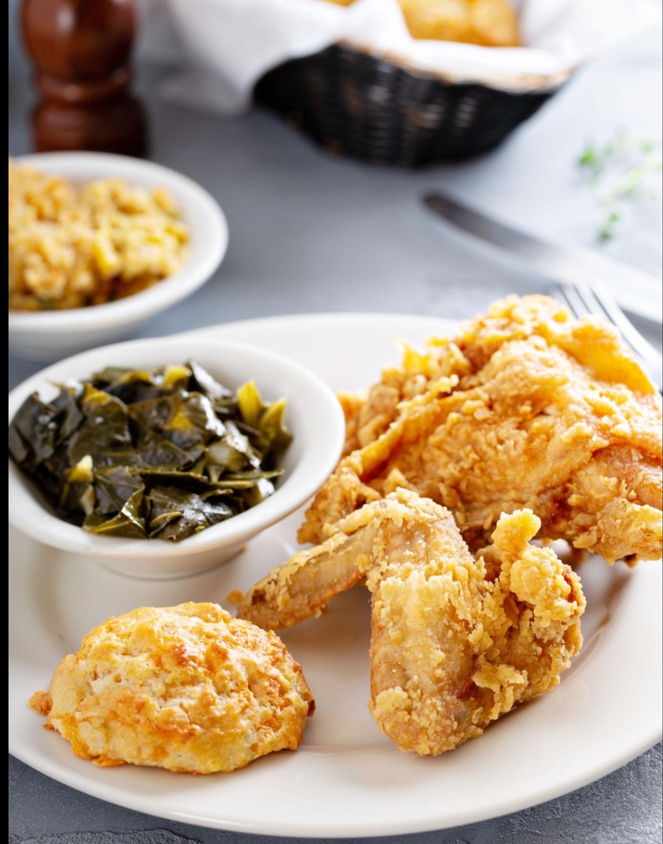 Golden fried chicken with collard greens and biscuit